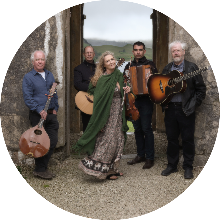 Altan stands holding their instruments in the doorway of what looks like an ancient castle or ruin in the Irish countryside