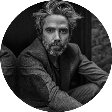 Patrick Watson looks forward in a black and white photo